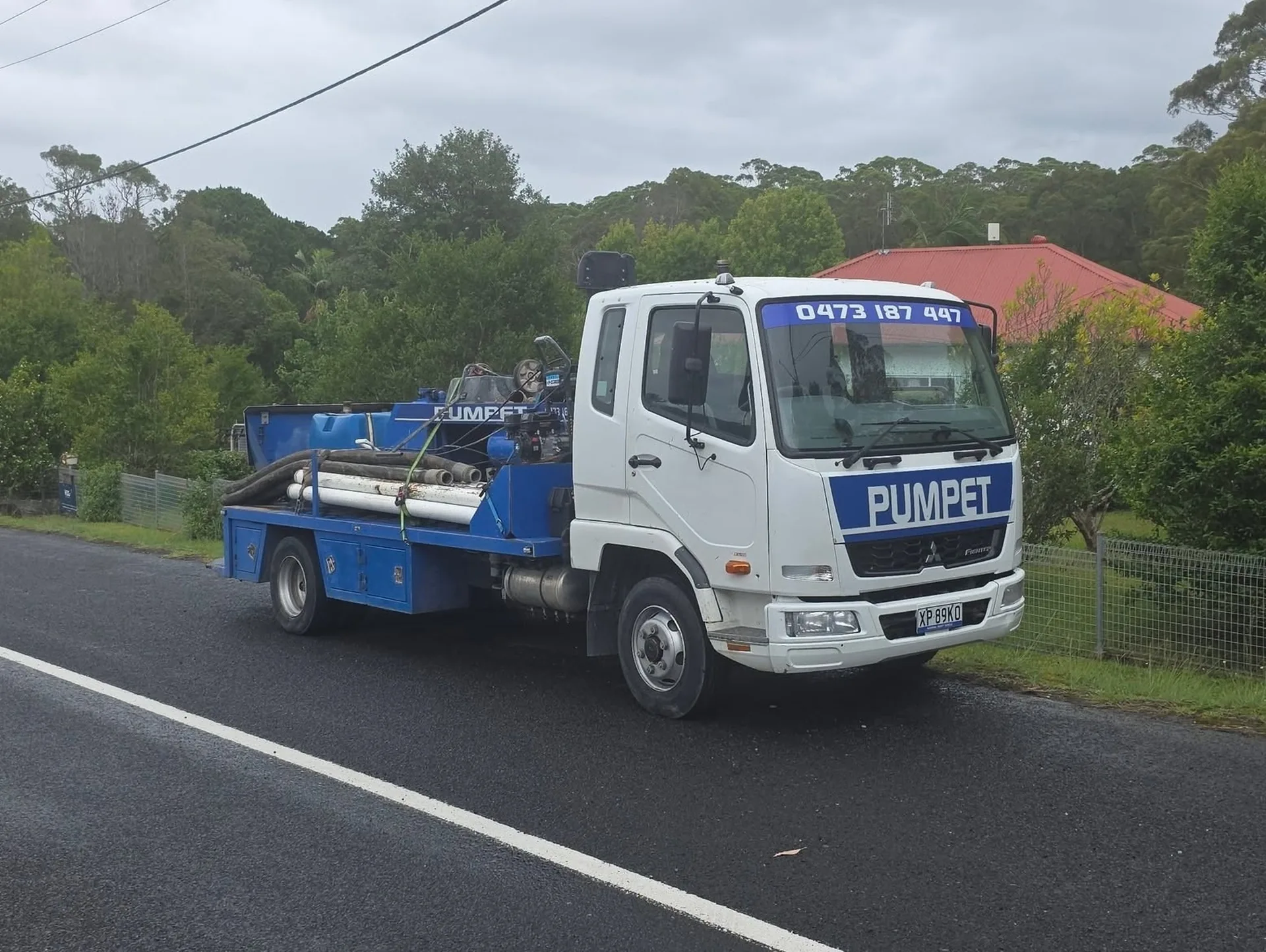 Pumpet concrete pumping truck with hoses loaded, parked roadside on the NSW South Coast