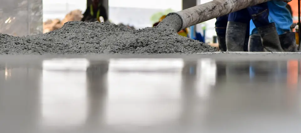 Wet concrete being discharged from the pump hose onto a freshly screeded slab