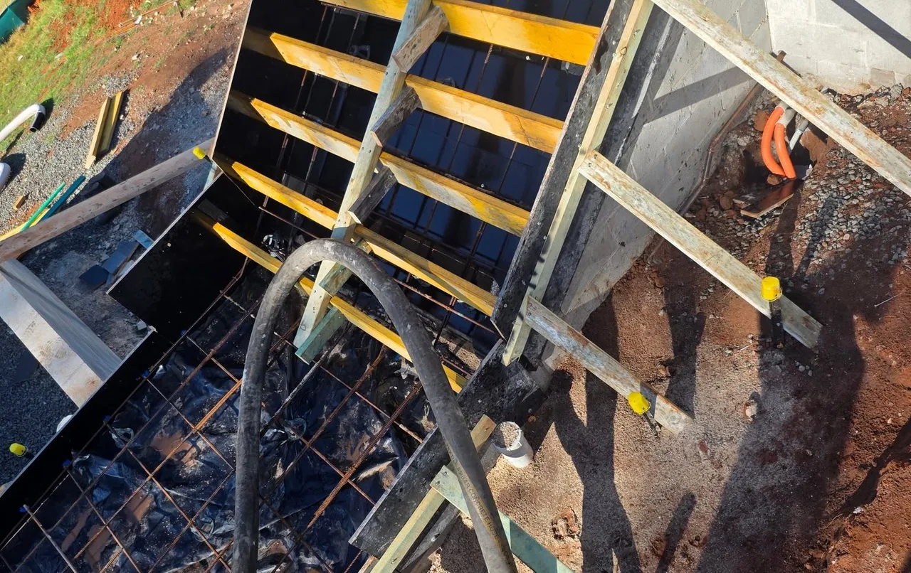Reinforcement mesh laid across a steep, stepped foundation on a sloped South Coast block